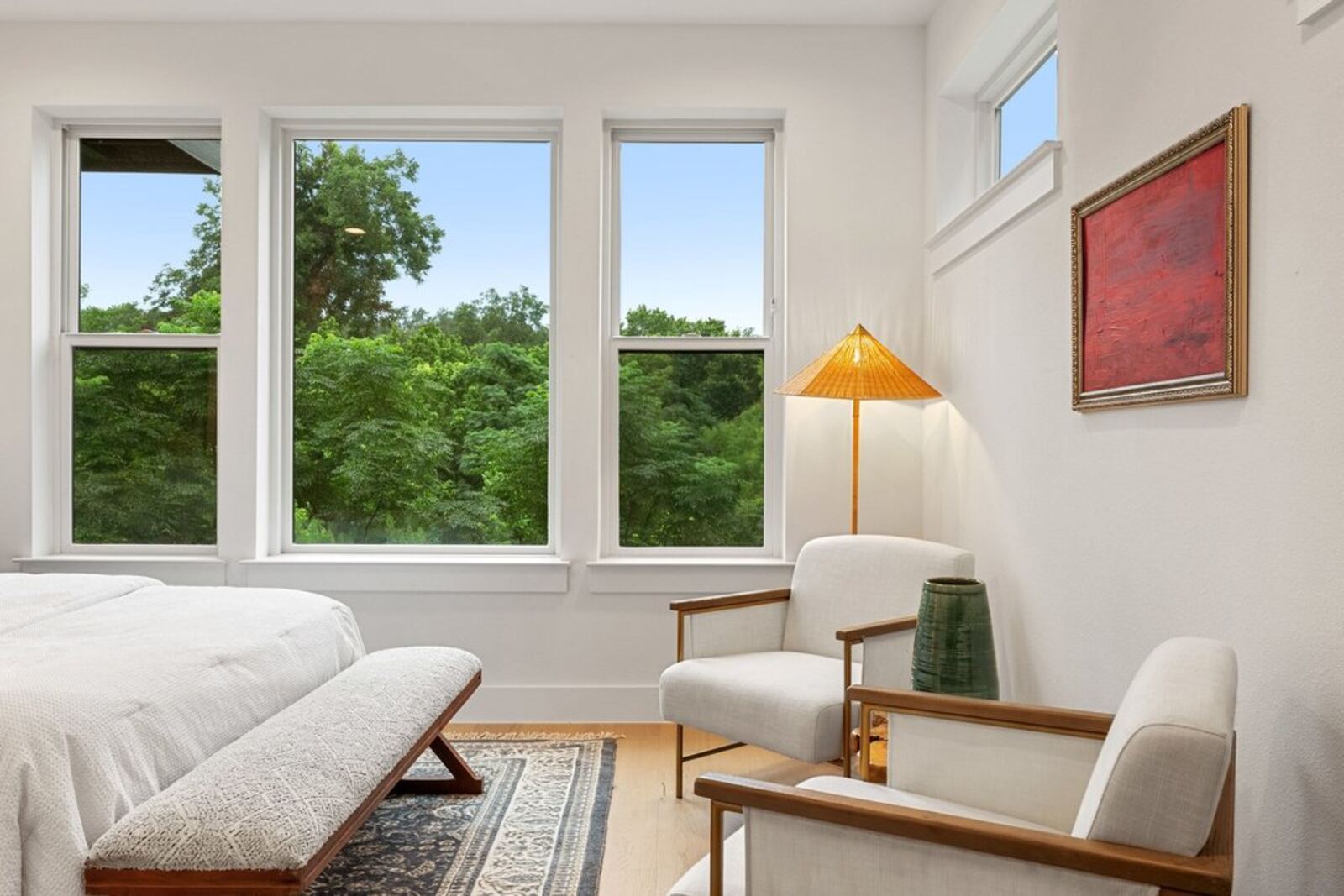 Primary bedroom with natural light and treetop views