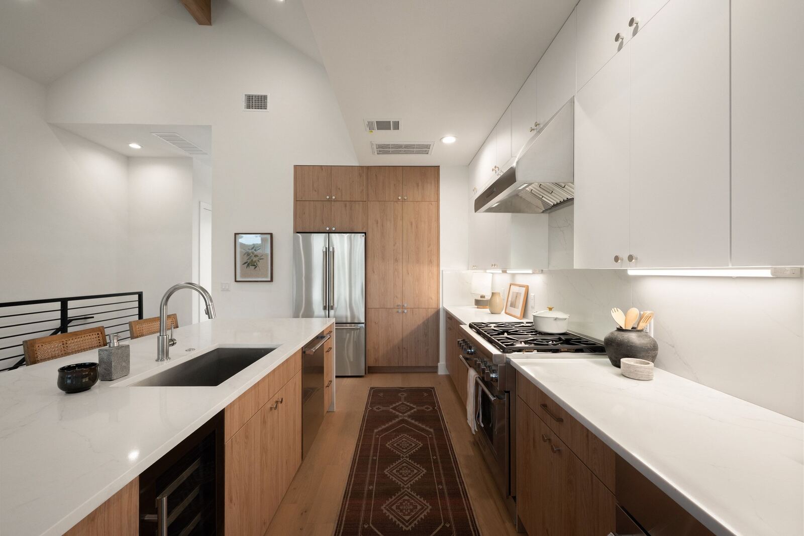 Kitchen with waterfall island, wood cabinetry and range