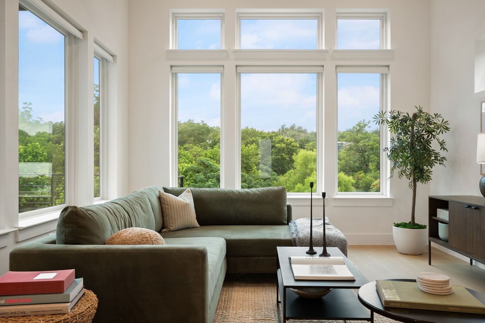 Living room with green sectional and greenbelt views